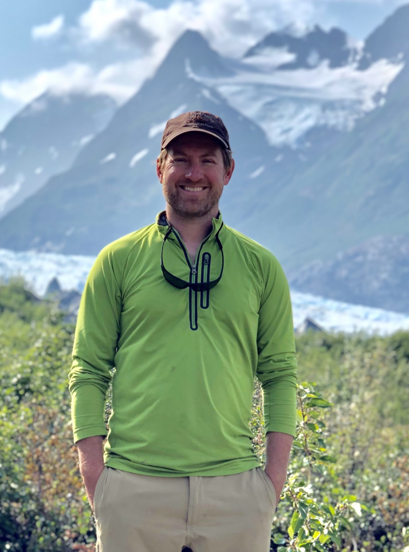 Photo of Paul Schuette standing in front of a mountain and a glacier in a valley.