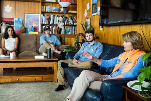 Sen. Lisa Murkowski sits on a sofa with a student in the Honors College in the Honors House. Two other students sit on an adjacent sofa.