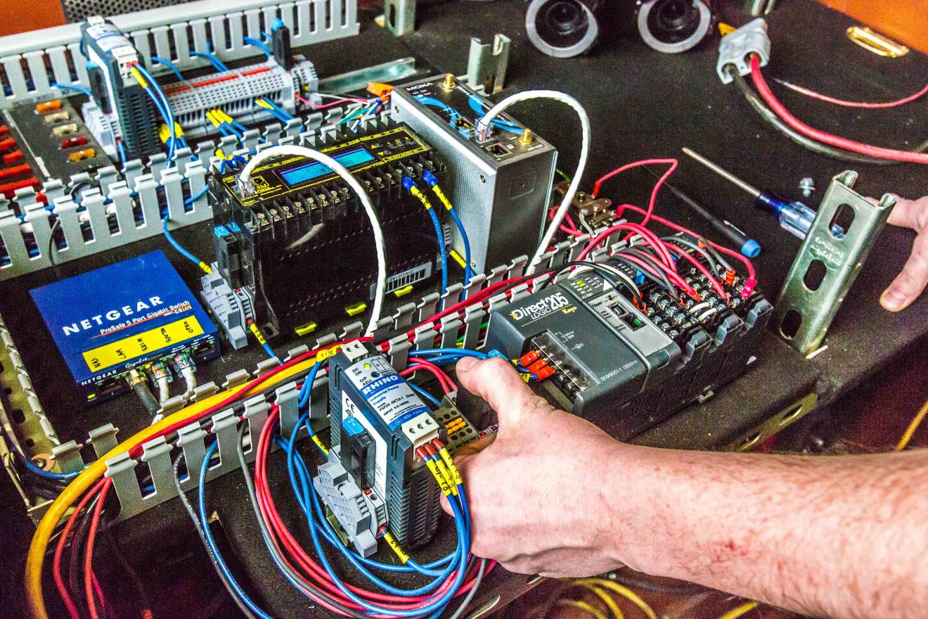 A hand reaches into a microgrid communications processor.