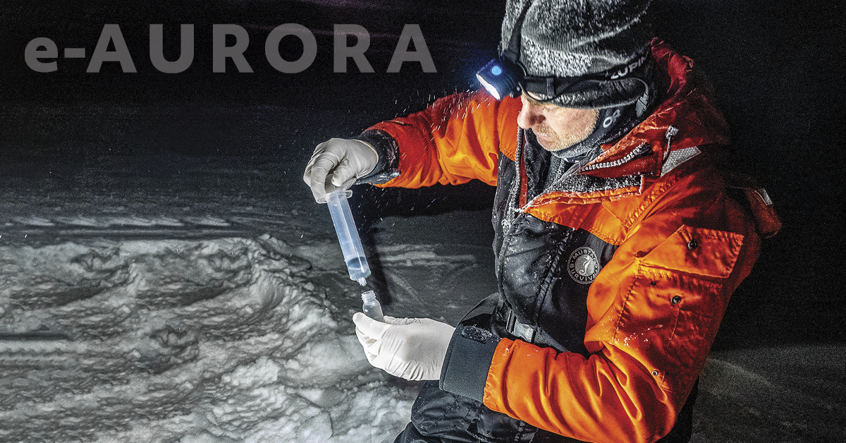 e-Aurora cover image of man in winter gear filling or emptying a syringe into or from a bottle. It is dark and snowing.