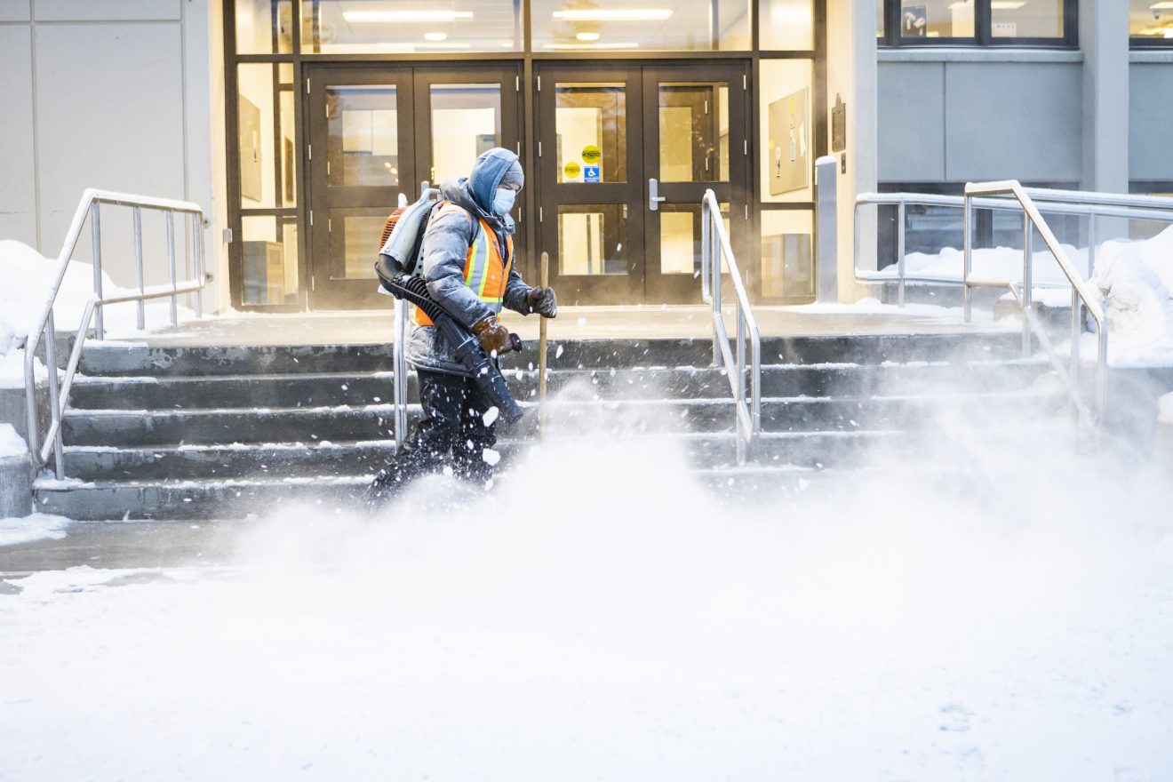 Person blowing snow off steps.
