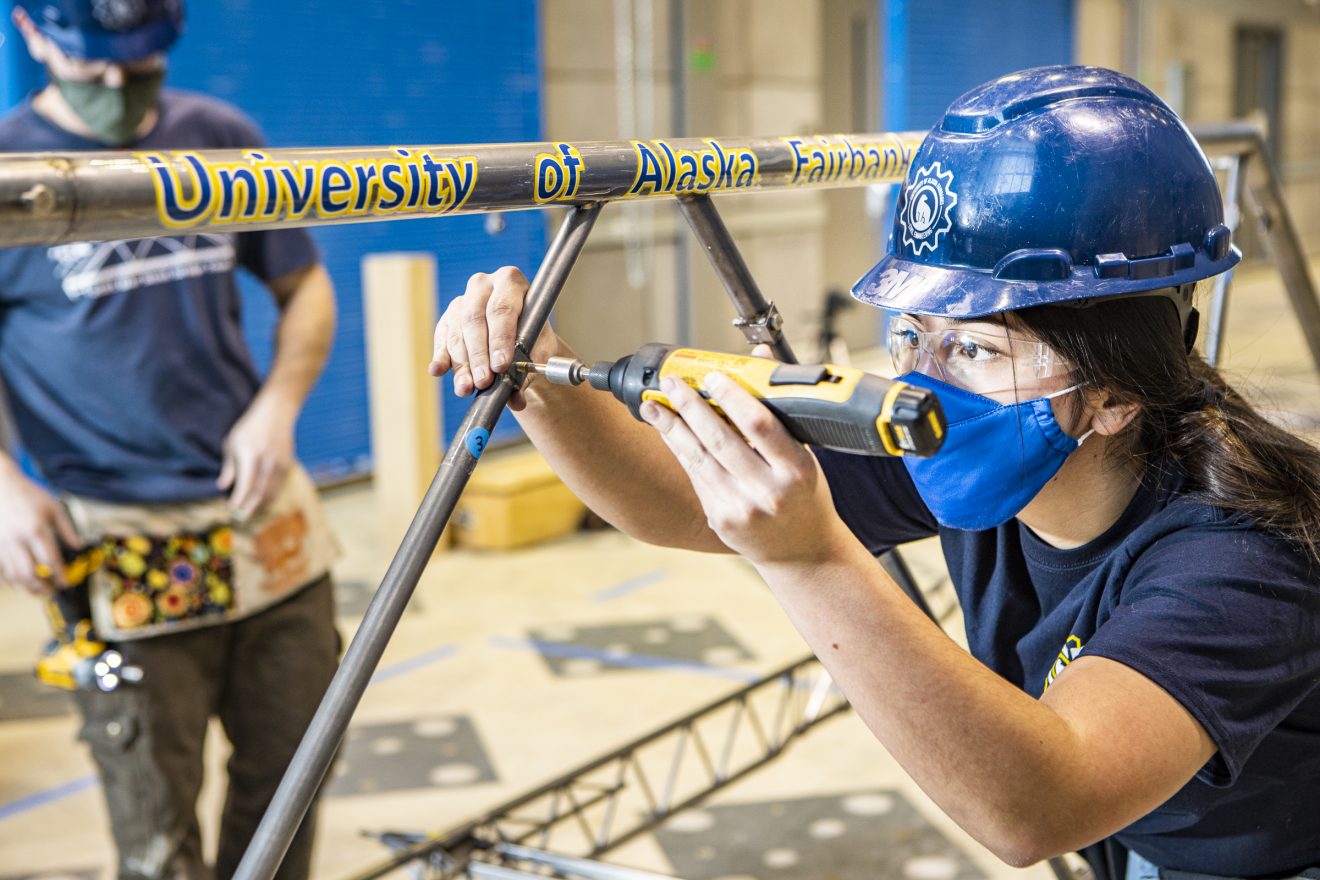 UAF photo by JR Ancheta. Jenna Hernandez tightens bolts on this year's steel bridge during a practice session.