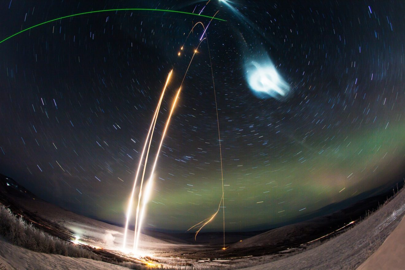 Photo credit: NASA’s Wallops Flight Facility/Poker Flat Research Range/Zayn Roohi. Time lapse of the Super Soaker launch on Jan. 25-26, 2018.. Three rockets launched with the mission, two using vapor tracers to track wind movement and one releasing a water canister to seed a polar mesospheric cloud. The green laser beam visible at the top left is the LIDAR beam used to measure the artificial cloud.