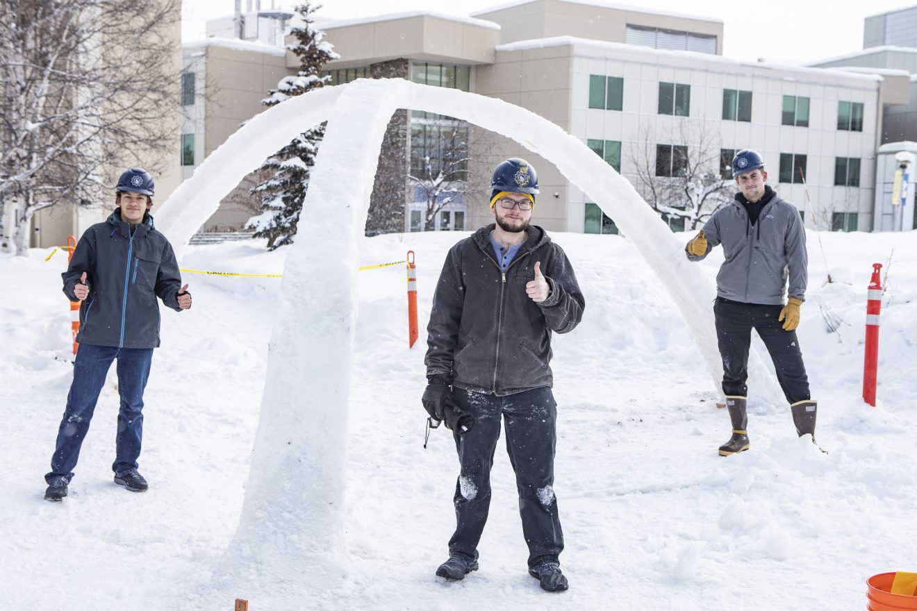 University of Alaska Fairbanks civil engineering students, from left, Dominic Russo, Zachery Miller and Jacob Lovaas, pose in front of the 2021 version of UAF’s ice arch. UAF photo by JR Ancheta