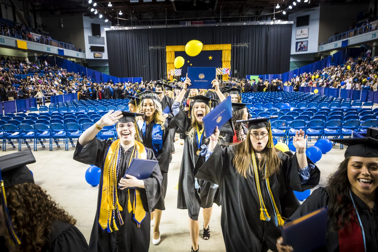 Graduates dance to the beat provided by Ensemble 64.8, a percussion group, as they leave the Carlson Center following UAF's commencement ceremony in Fairbanks May 5, 2018.