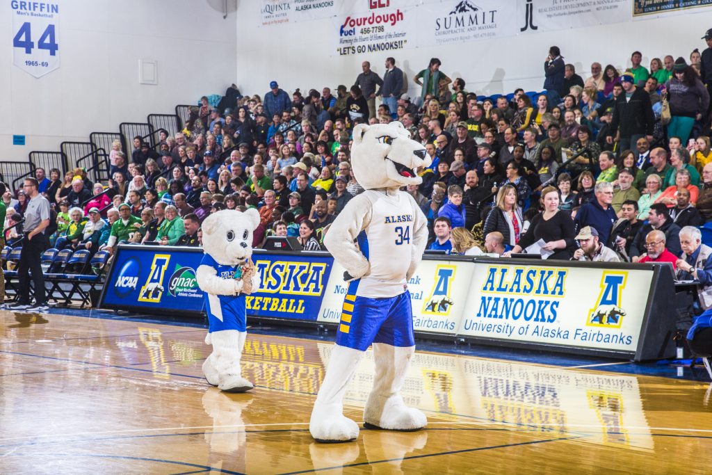 Small Nanook mascot and large one prance along the court in front of a full crowd.