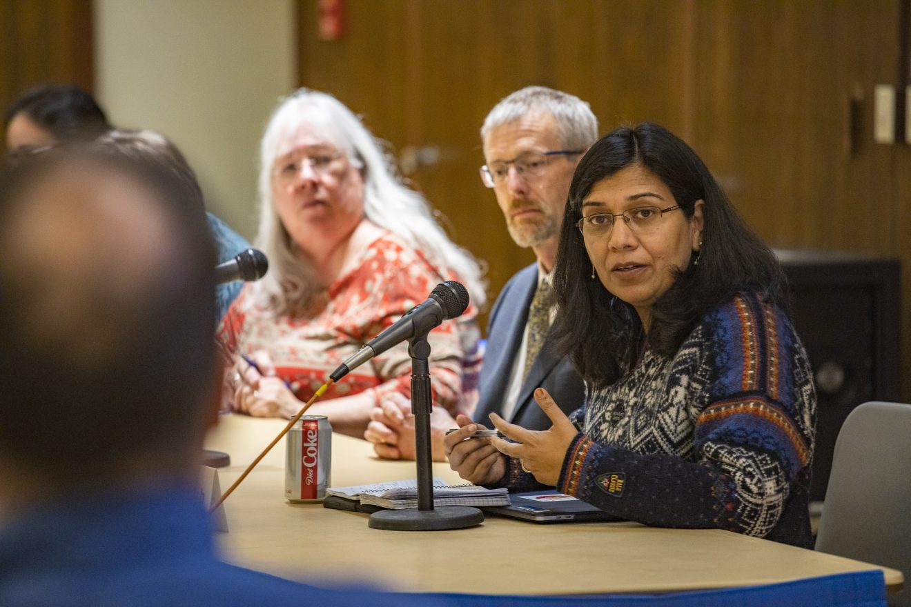 Provost Anupma Prakash, right, speaks during a Faculty Senate meeting Monday, Oct. 7, 2019. Faculty Senate President Sine Anahita sits to the far left, with Chancellor Dan White in the middle. All three are sitting at a table. The provost has a microphone in front of her.