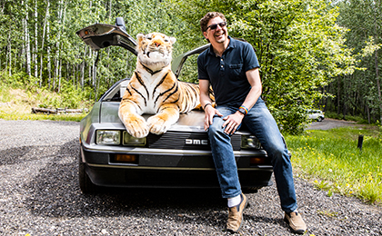 Rob Prince poses with his Bengal tiger and DeLorean
