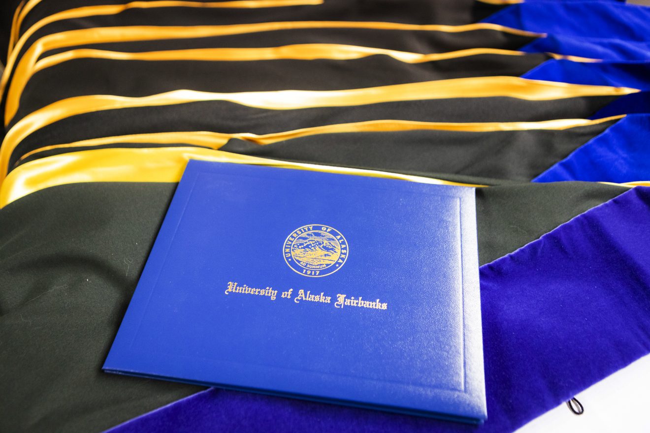 diploma cover on a table of blue and gold sashes