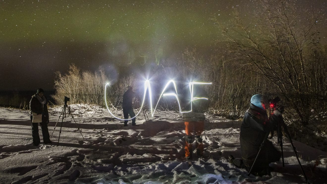Someone uses light to paint UAF against the aurora.