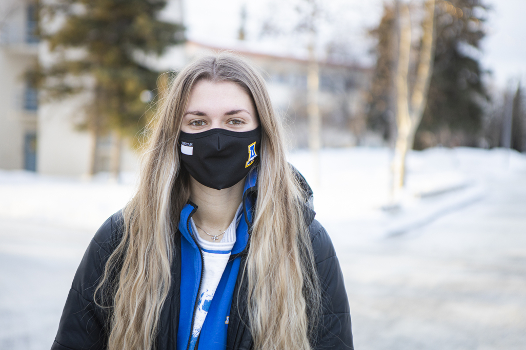Young woman wearing a mask outside