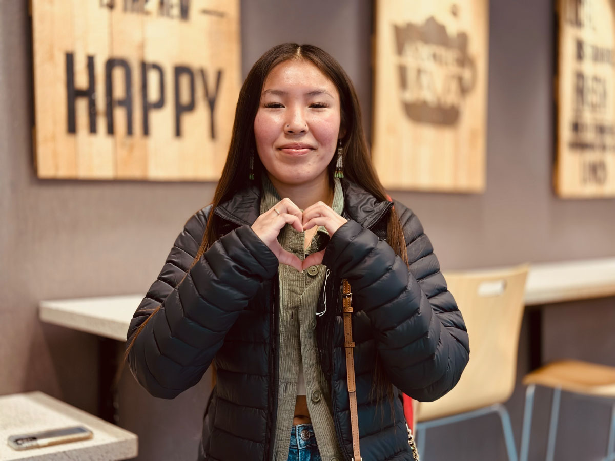 A student in Arctic Java in the UAF Wood Center makes a heart with her hands