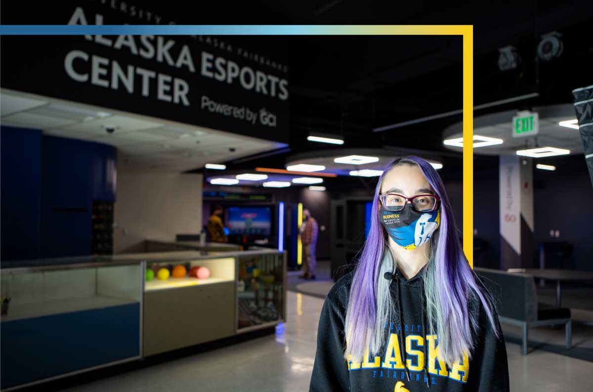 Esports student worker Shayna stands in the Wood Center in front of the entrance to the Esports Center