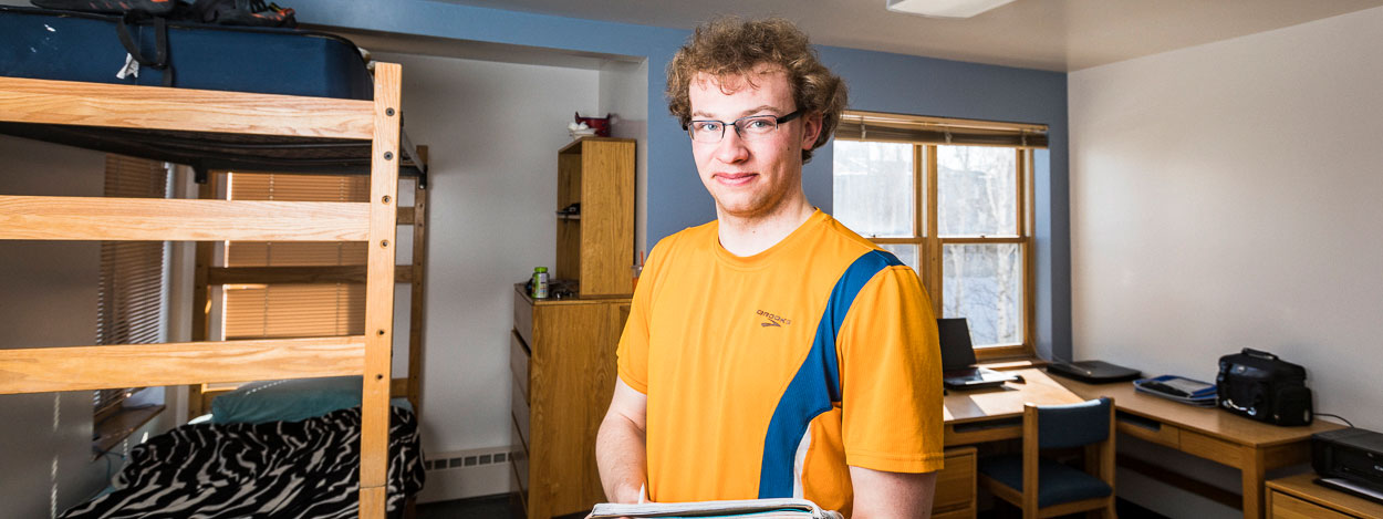 UAF student poses in his Cutler Apartments room on the Fairbanks campus