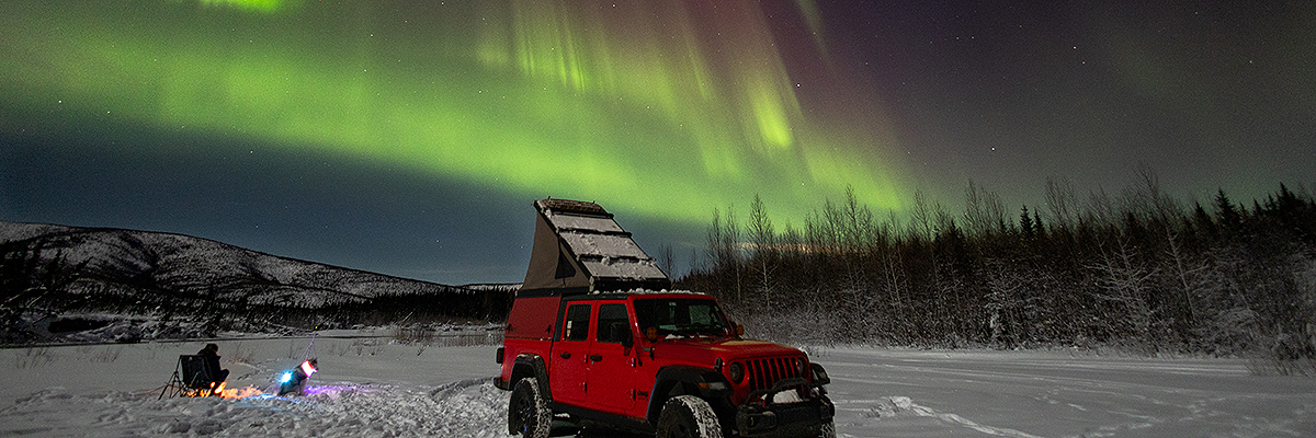 Camping at the Chena River Recreation Area on a winter night as the Aurora dances in the sky. Photo by Adam Rubin.