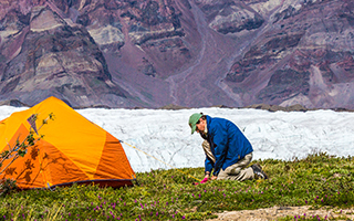 Researcher camping on snow covered mountain