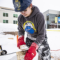 Student cutting ice for ice bridge