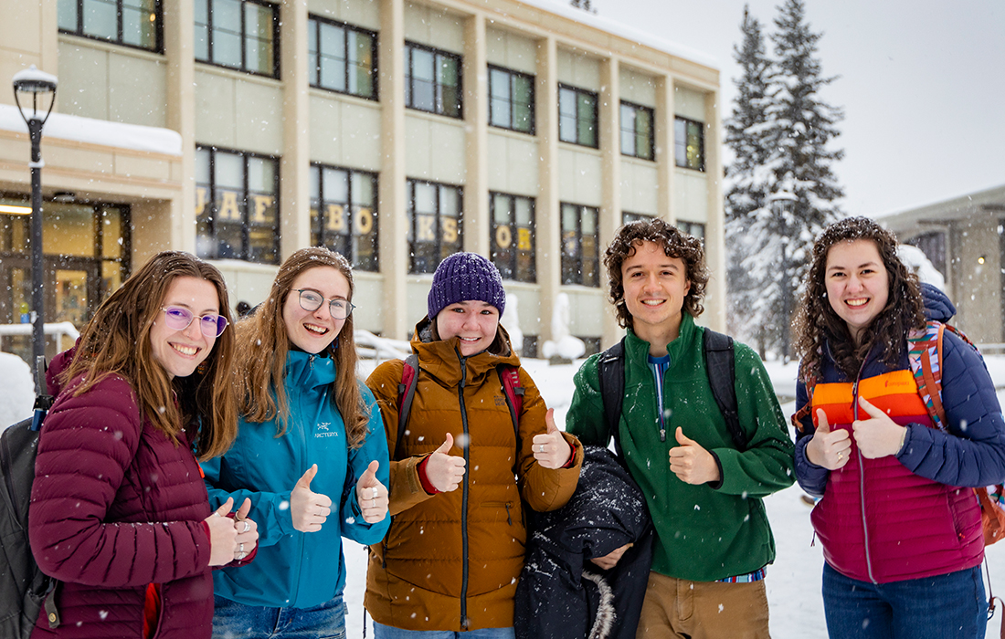 A group of students take a photo together as they return to the snowy Troth Yeddha' Campus on the first day of the 2024 Spring Semester. UAF Photo by Leif Van Cise.