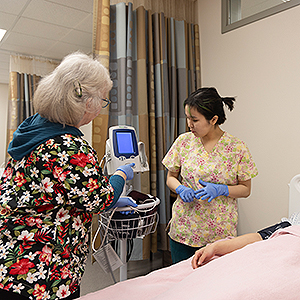 Benice Tinker of the Nurse Aide program practices taking a patient's blood pressure on fellow classmate Prescilla Choi under the guidance of instructor Mary Meier in the CTC downtown facility. UAF Photo by Leif Van Cise