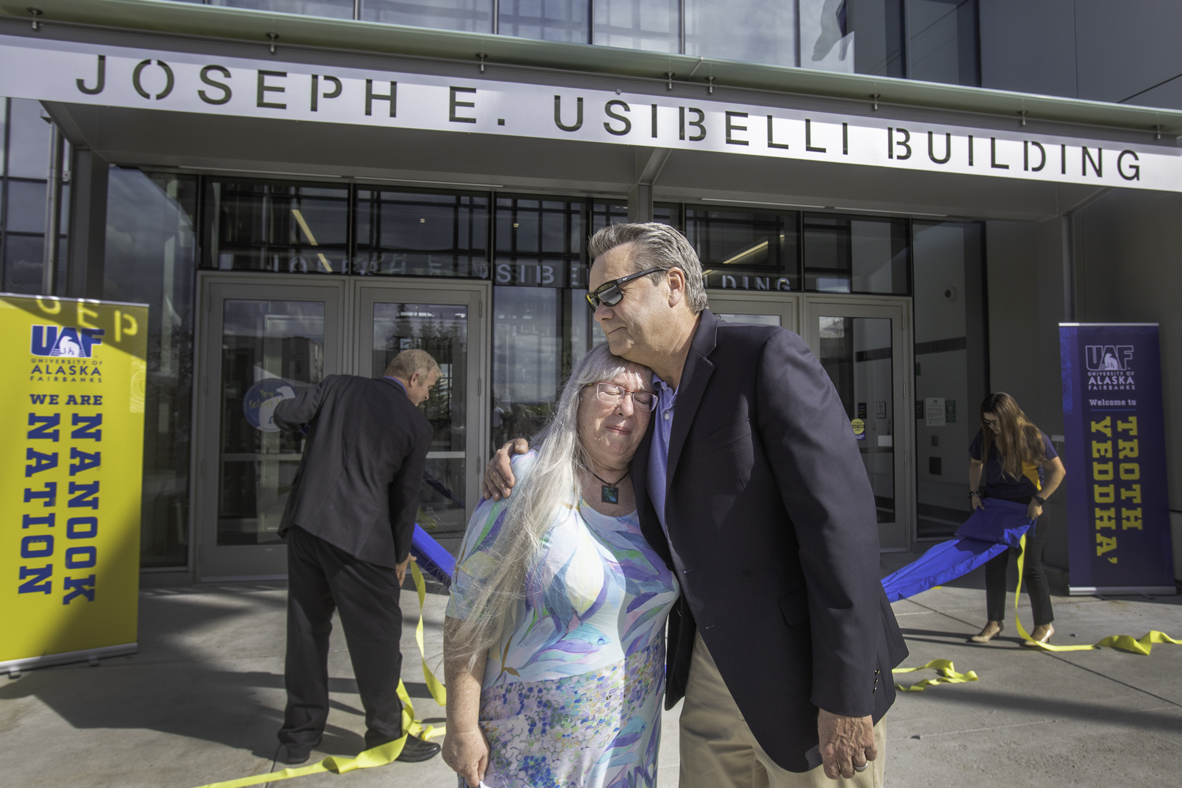 Peggy Shumaker, wife of the late Joe Usibelli, and Joe Usibelli Jr. share an emotional moment after unveiling. UAF photo by Eric Engman.