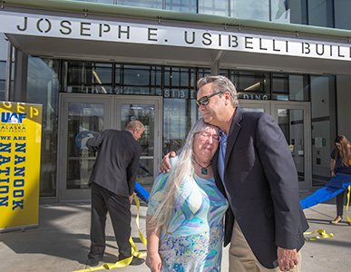 Peggy Shumaker, wife of the late Joe Usibelli, and Joe Usibelli Jr. share an emotional moment after unveiling the new sign during the Joseph E. Usibelli Engineering Learning and Innovation Building naming and dedication ceremony on the Fairbanks campus Thursday, Aug. 4, 2022. UAF photo by Eric Engman.
