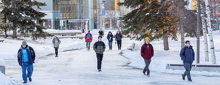 Students walking on snow covered campus grounds
