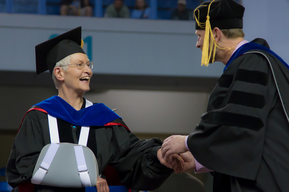 Retiring professor Mary Mangusso accepts congratulations from CLA Dean Eric Heyne for being granted emeritus status at UAF's 2010 commencement ceremony.