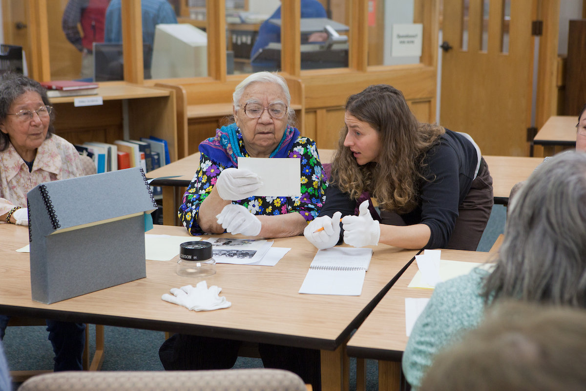 Staff members with the Alaska and Polar Regions Collection at the Rasmuson Library work with elders from the Koyukuk River villages of Huslia, Hughes and Allakaket identifying subjects in old photos recently added to the library's collection.. UAF Photo by Todd Paris