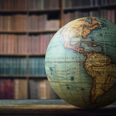 Globe in front of a shelf of books | Stock photo from Canva