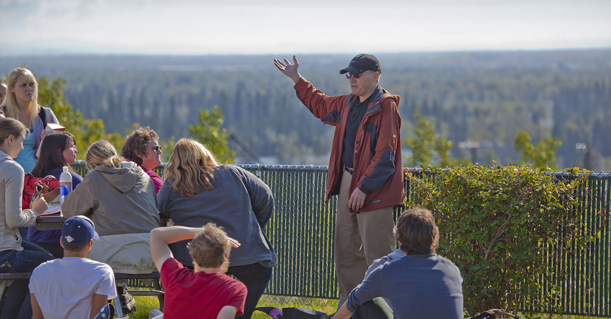 UAF history professor Terrence Cole, in black hat, lectures his History of Alaska students outdoors on the first day of classes of the fall semester.