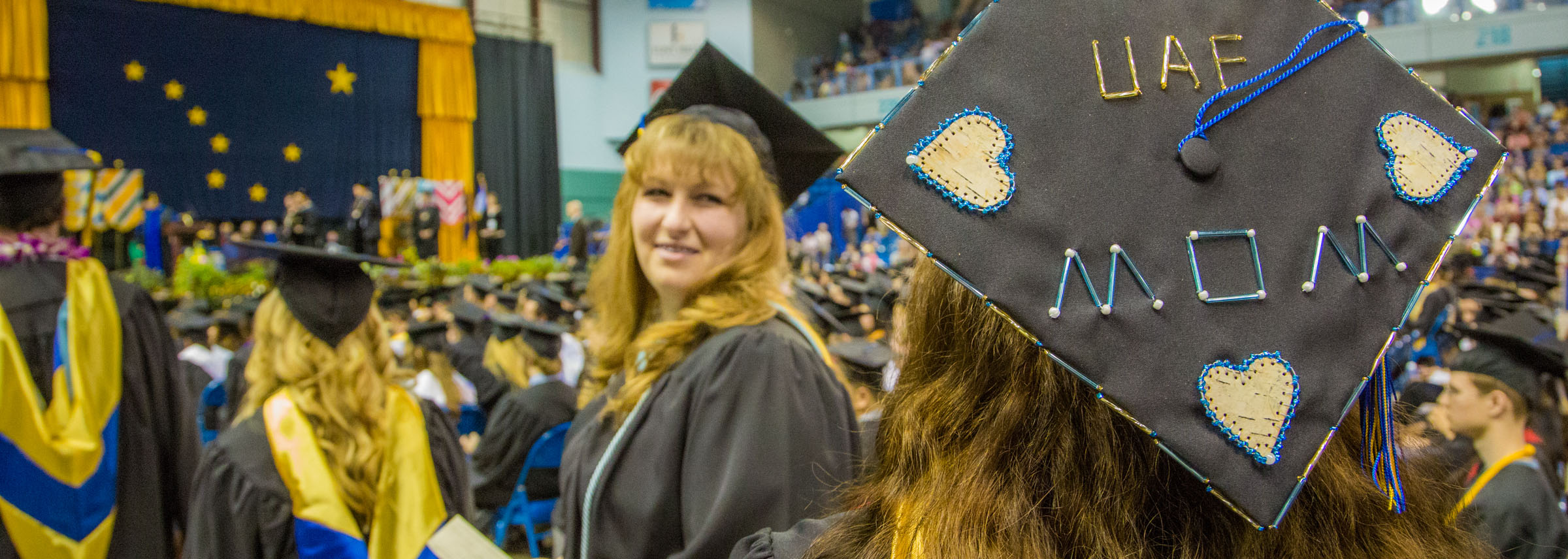 UAF mom and other graduates stand at Commencement.