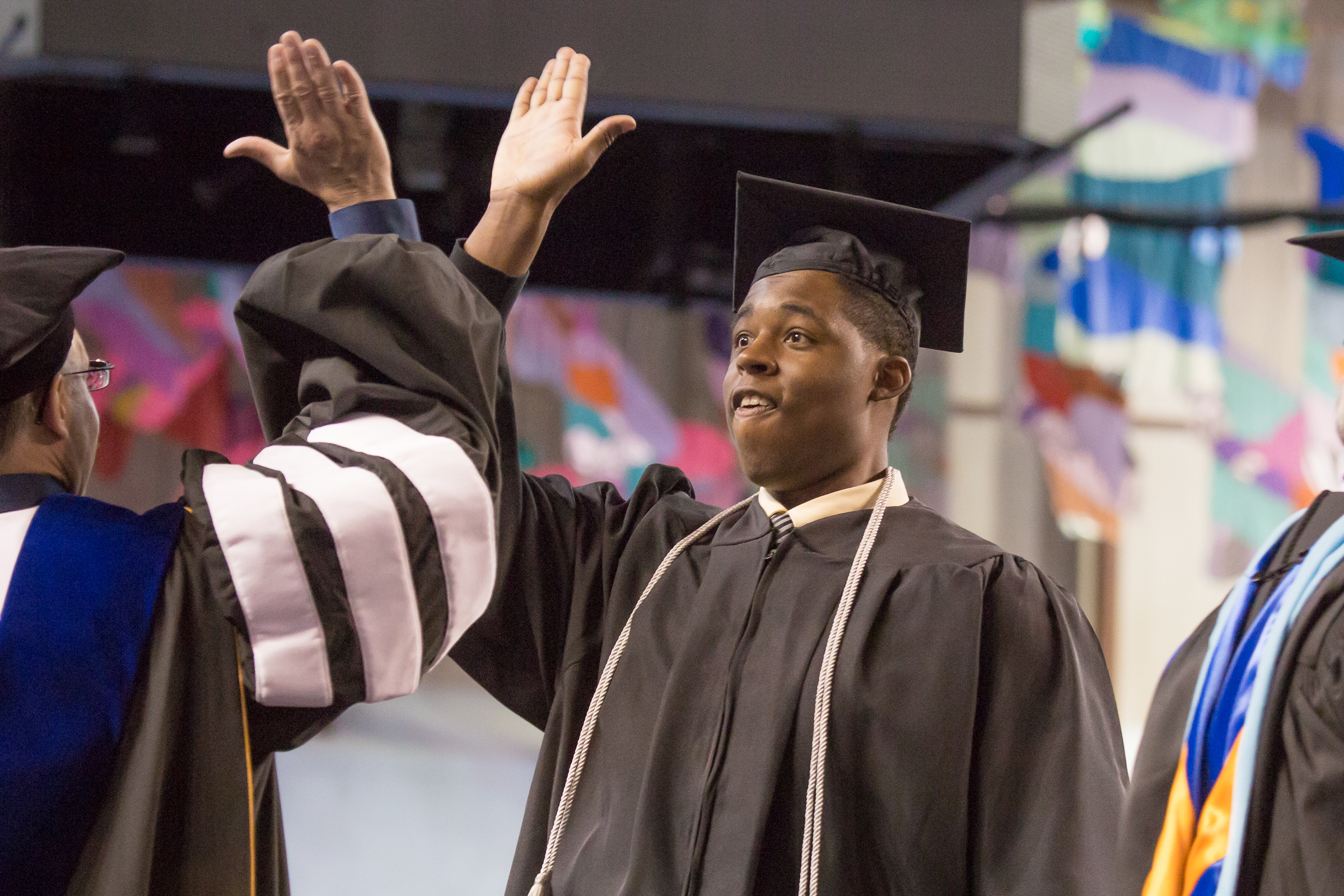 Robert Kinnard III shares a high five with Vice Chancellor Mike Sfraga after earning his degree in justice. | UAF Photo by Todd Paris