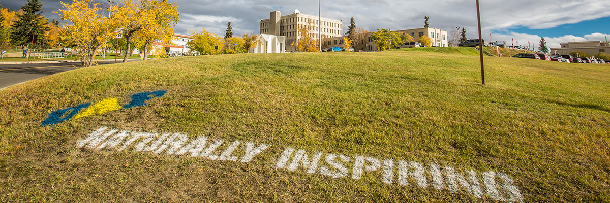 Naturally Inspiring tag on the lawn at UAF