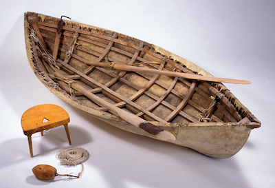 skin boat with oars and small stool