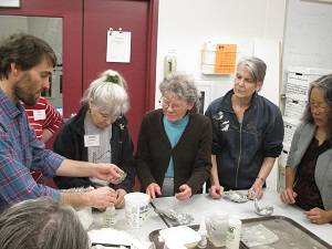Earth Sciences Curator Pat Druckenmiller shows fossils to a group of adults.