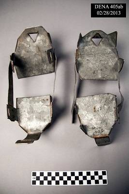 Pair of homemade metal crampons, viewed from above against a gray background.