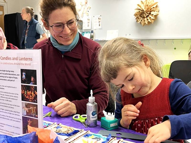 Adult and child work on a craft project together.