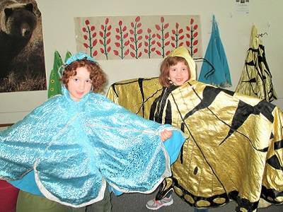 Two children pose in butterfly costumes.