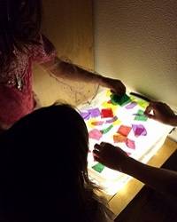 Children playing with a homemade light box.
