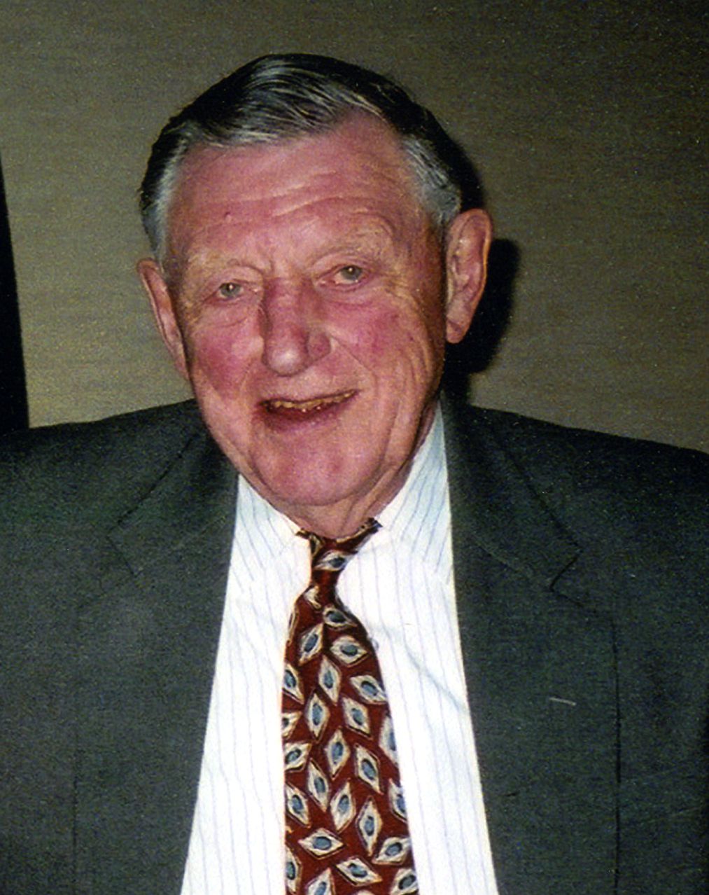 Image of Headshot of Bill Stroecker in gray suit with maroon tie