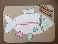Build A Fish example; a drawing of a fish with fins and other parts glued on, colored with crayons.