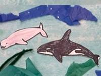 Collage showing an underwater scene, made with watercolors, yarn, and tissue paper. Several colored whale templates are glued to the collage.