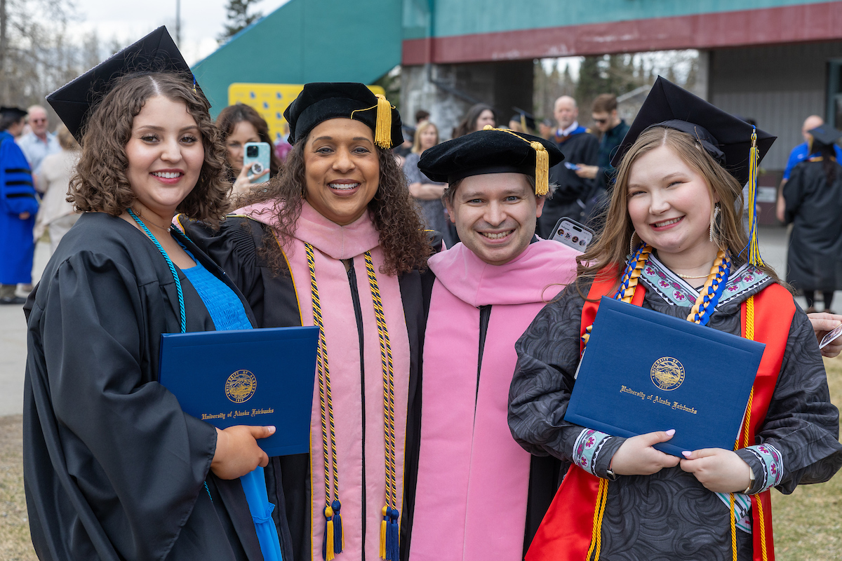 Department of Music Chair Jaunelle Celaire, second from left, and adjunct instructor Daniel Strawser, third from left, pose with graduating students  Ariana Lopez, left, and Ellie Martinson, right,during the University of Alaska Fairbanks 2024 Commencement Ceremony Saturday, May 4, 2024 at the Carlson Center. UAF Photo by Eric Engman