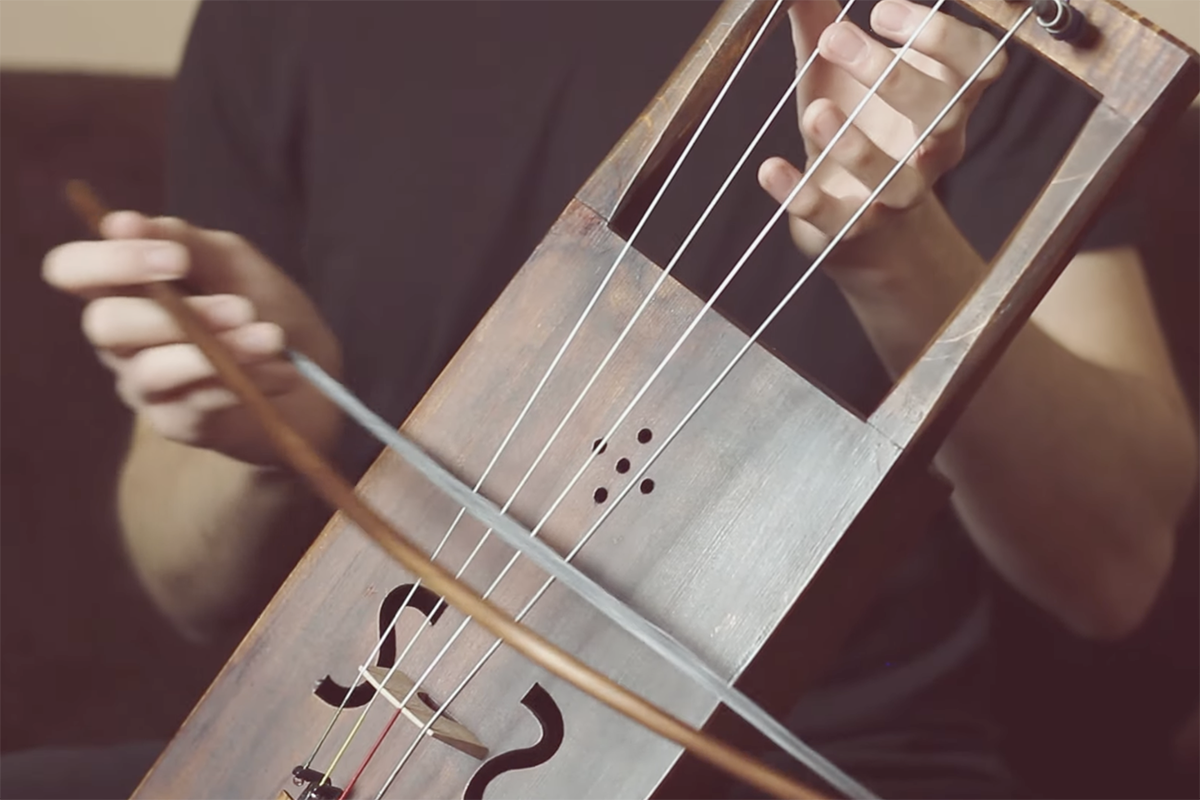 Close up of musician's hands playing a tagelharpa | Screenshot from YouTube video by Jirka Hájek of a tagelharpa cover of Myrkur's Leaves of Yggdrasil