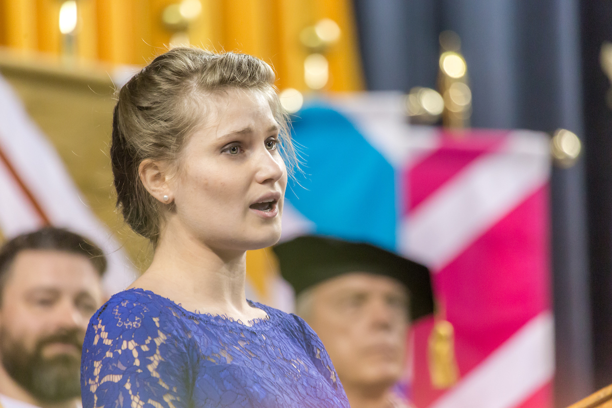 Music major Kaylee Miltersen sings the Alaska Flag Song near the conclusion of UAF's 2015 commencement ceremony May 10 in the Carlson Center. UAF Photo by Todd Paris