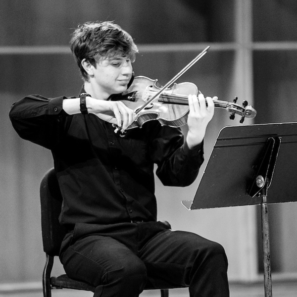 Violin player on stage in the Davis Concert Hall. UAF Photo by Marina Santos