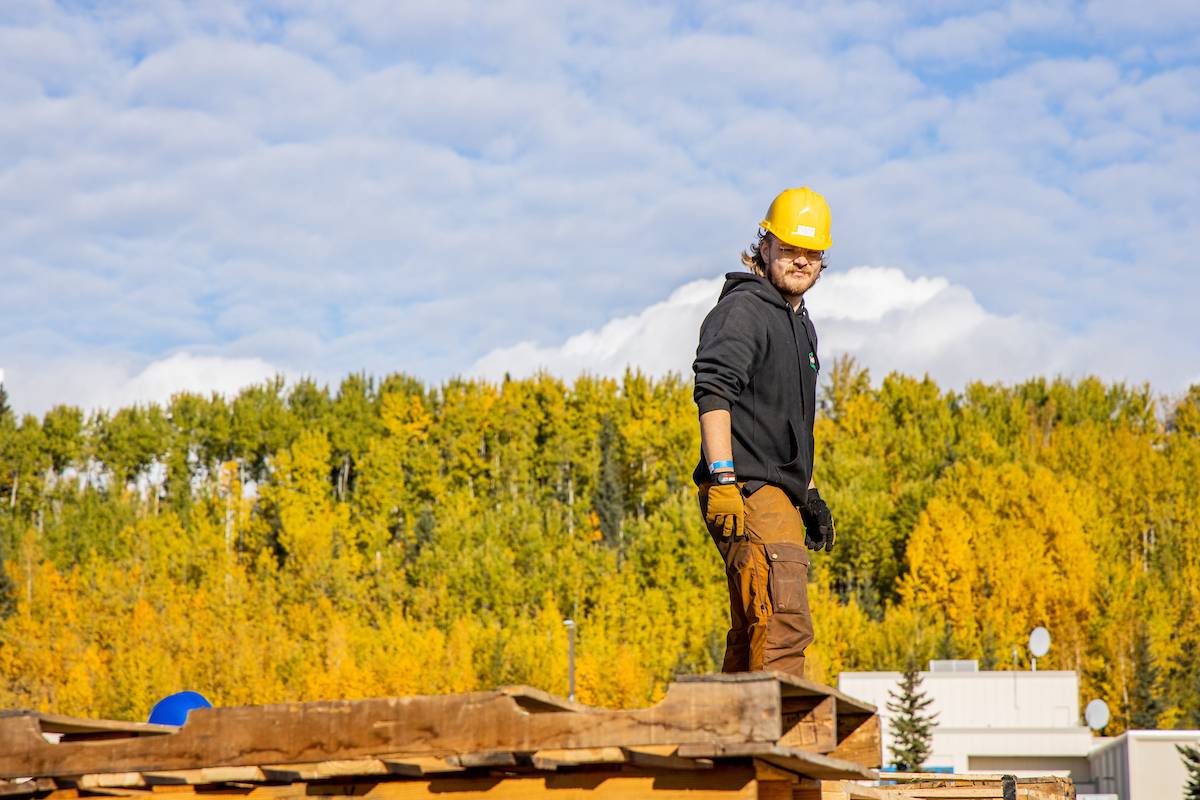 Eli assists with building a bonfire for UAF's annual fall Nanook Tradition, Starvation Gulch