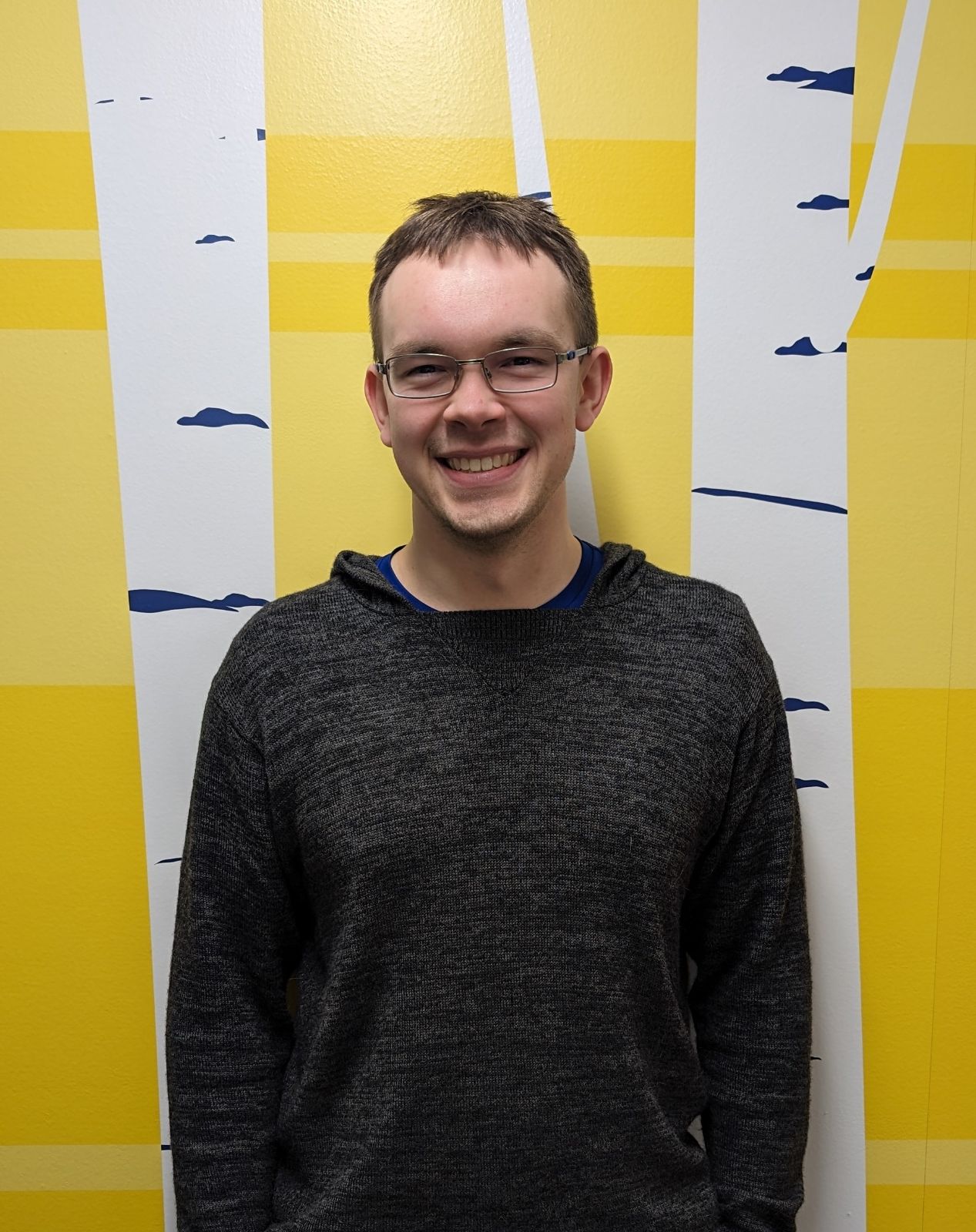 Josef Maier standing in front of a yellow/white background.
