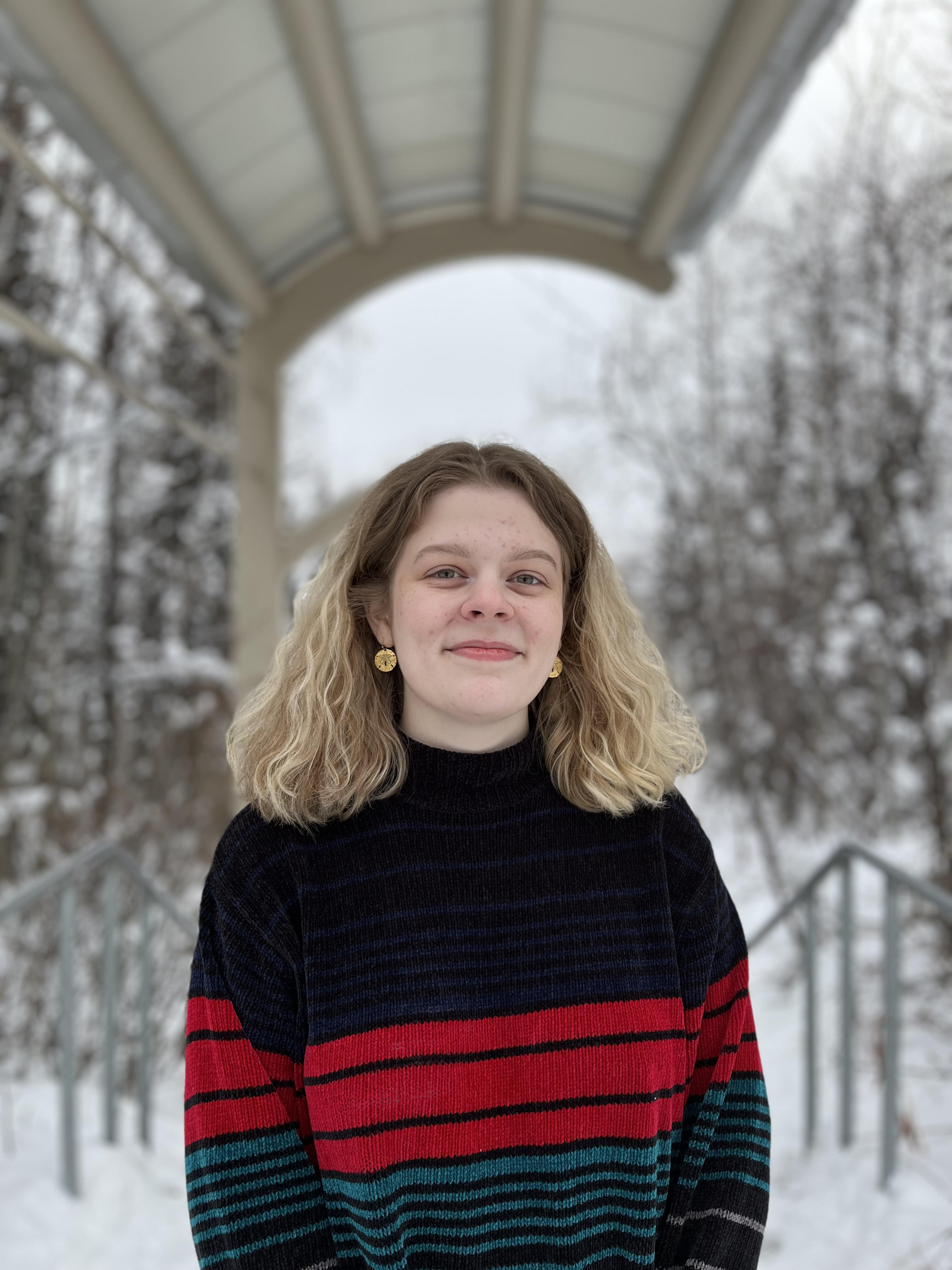 Olivia Ryan in front of winter forest background.
