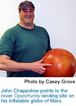 John Chappelow points to the rover Opportunity landing site on his inflatable globe of mars.